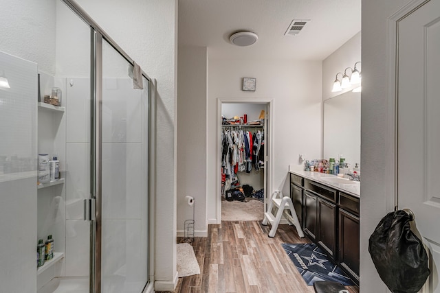 bathroom with vanity, wood-type flooring, and an enclosed shower