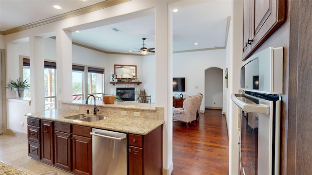 kitchen with light stone countertops, ceiling fan, sink, light hardwood / wood-style floors, and ornamental molding