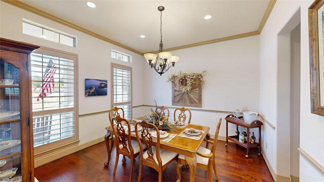 dining space with a notable chandelier, dark hardwood / wood-style floors, and ornamental molding