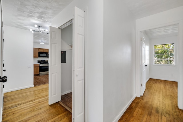 corridor featuring light hardwood / wood-style flooring and a chandelier