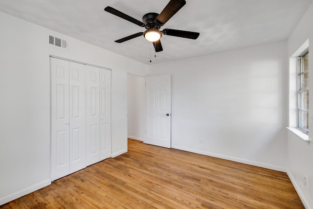 unfurnished bedroom with ceiling fan, a closet, and light hardwood / wood-style flooring