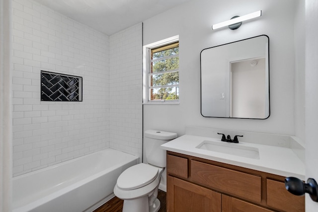 full bathroom featuring vanity, wood-type flooring, tiled shower / bath combo, and toilet