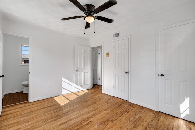 unfurnished bedroom with ceiling fan, light wood-type flooring, and ensuite bath