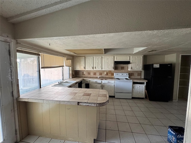 kitchen featuring tile counters, white electric range, kitchen peninsula, a textured ceiling, and black refrigerator