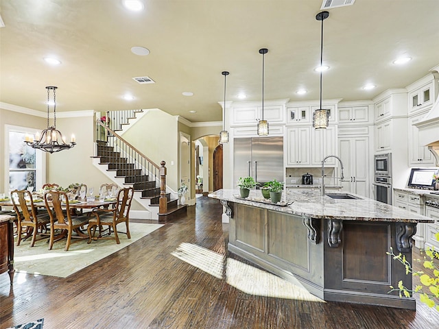 kitchen featuring a breakfast bar, dark wood-type flooring, a spacious island, sink, and stainless steel appliances