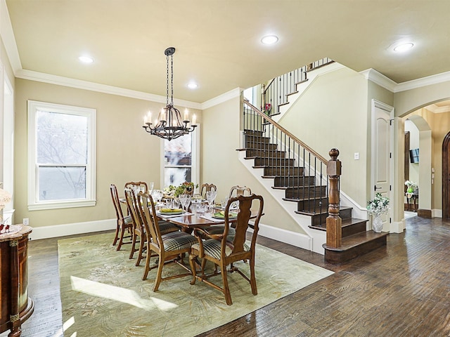 dining room with dark hardwood / wood-style flooring, crown molding, and a chandelier