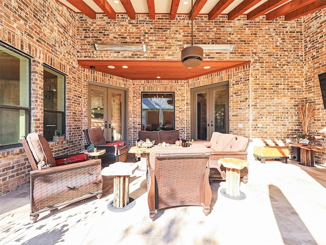 snow covered patio with outdoor lounge area and french doors