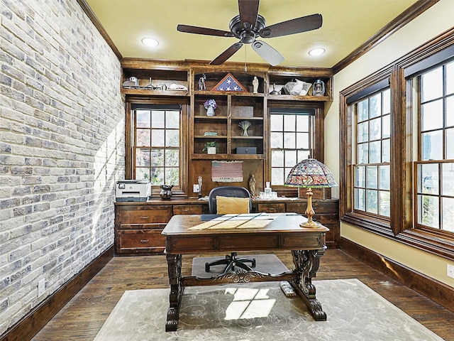 office space with crown molding, dark hardwood / wood-style flooring, ceiling fan, and brick wall