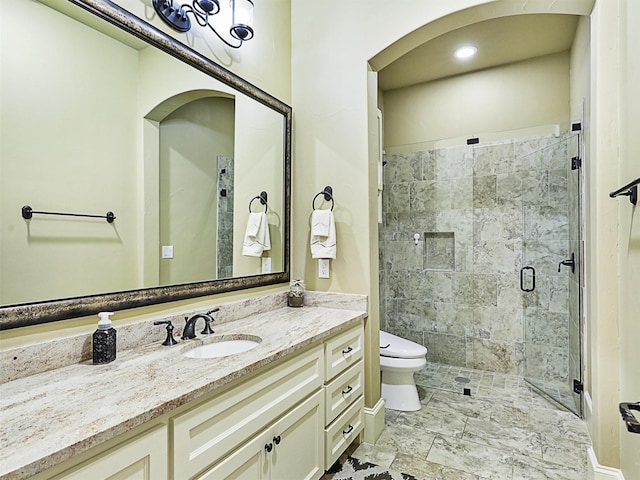 bathroom with vanity, an enclosed shower, and toilet