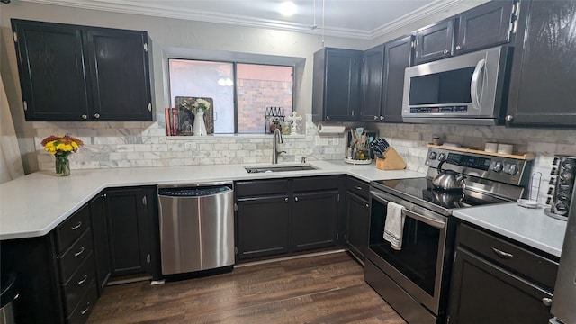 kitchen featuring sink, ornamental molding, appliances with stainless steel finishes, dark hardwood / wood-style floors, and decorative backsplash