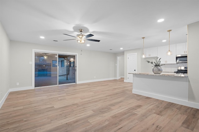 unfurnished living room featuring ceiling fan and light hardwood / wood-style flooring