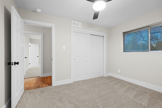 unfurnished bedroom with carpet, a closet, and ceiling fan