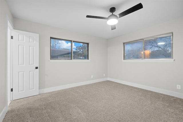 carpeted spare room with ceiling fan