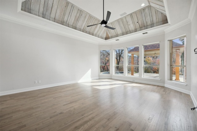 spare room with baseboards, a tray ceiling, ceiling fan, and wood finished floors