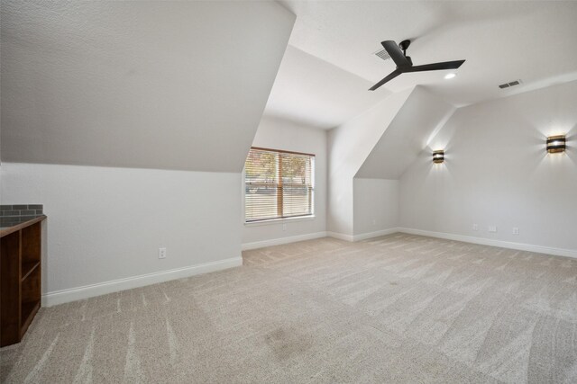 empty room with ceiling fan, light colored carpet, and a wealth of natural light