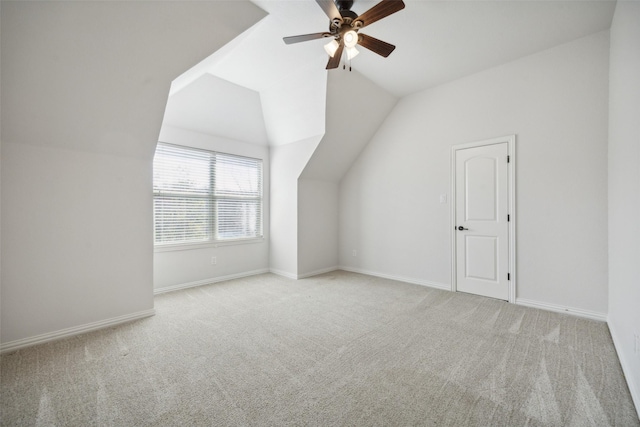 additional living space with ceiling fan, light colored carpet, and vaulted ceiling