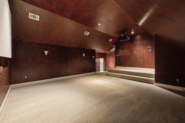 cinema room featuring lofted ceiling, baseboards, visible vents, and carpet flooring