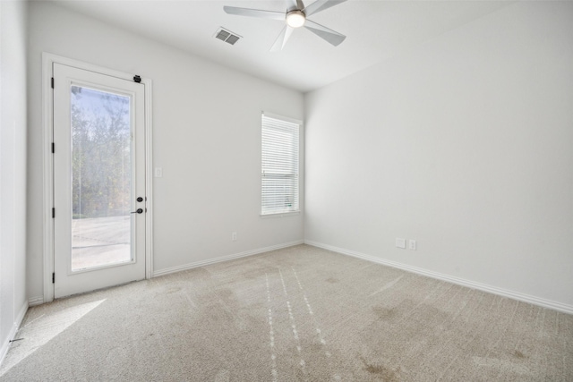 empty room with carpet, visible vents, and plenty of natural light