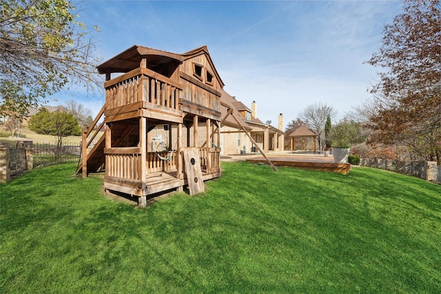 back of house featuring a deck, a yard, and fence