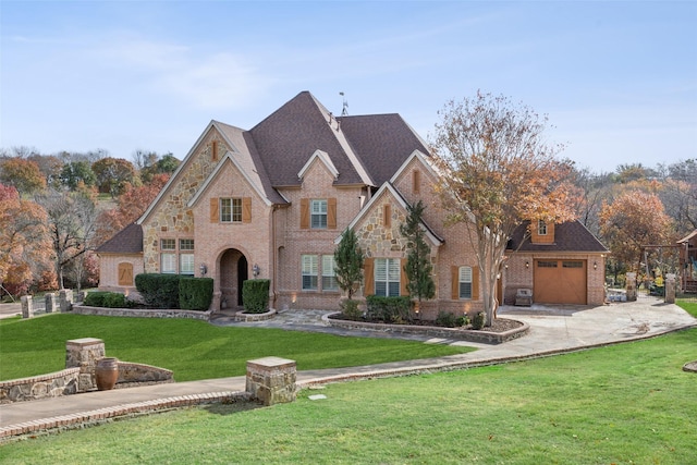 french country style house featuring concrete driveway, brick siding, roof with shingles, and a front yard