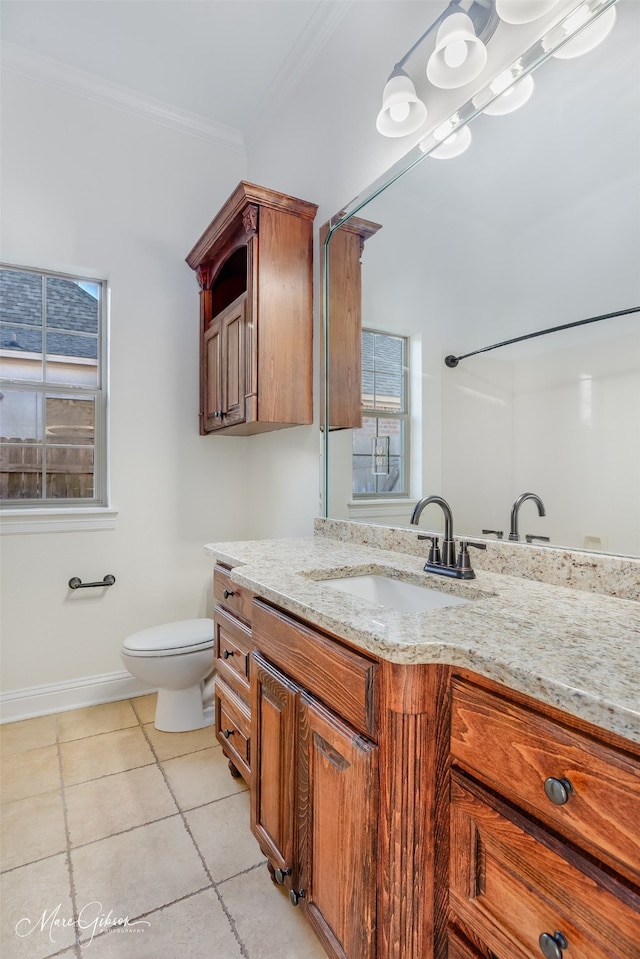 bathroom featuring ornamental molding, a healthy amount of sunlight, toilet, and vanity