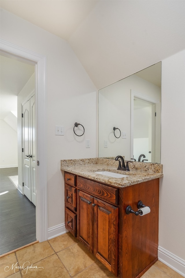 bathroom featuring lofted ceiling and vanity