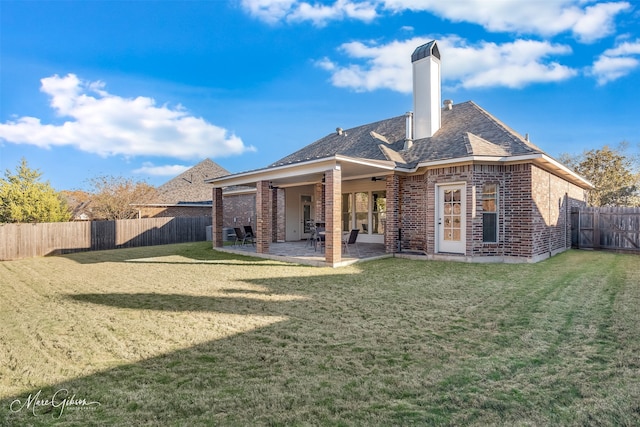 rear view of property featuring a yard and a patio