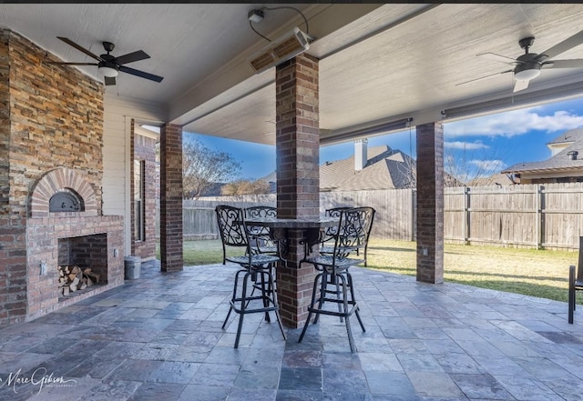 view of patio / terrace featuring an outdoor brick fireplace and ceiling fan