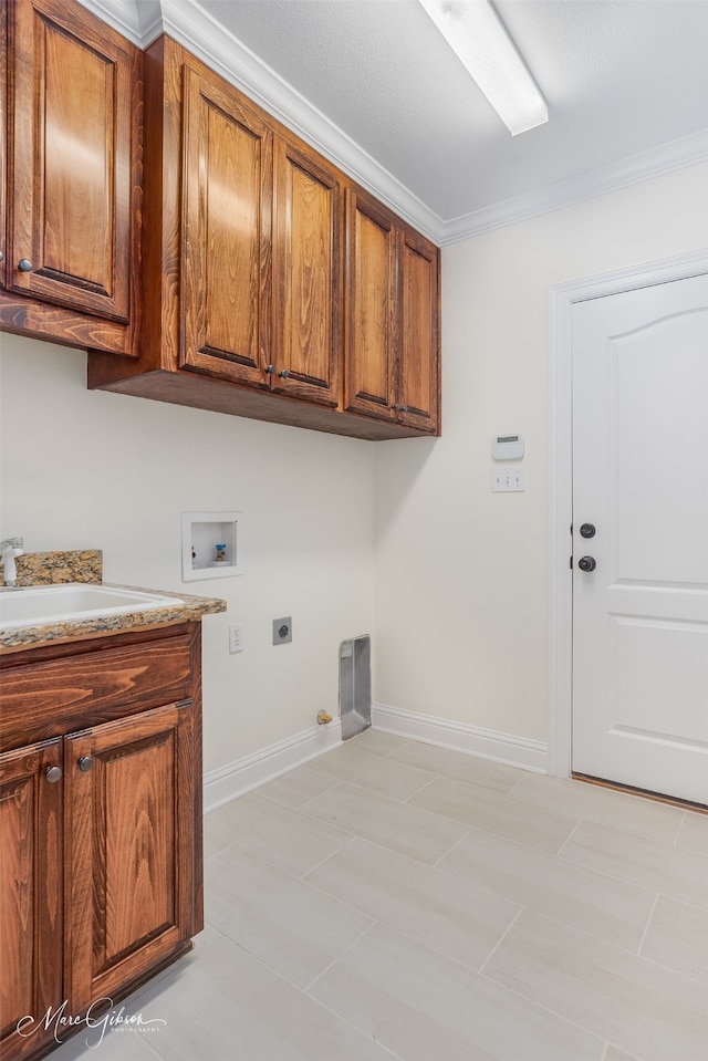 laundry room featuring sink, electric dryer hookup, hookup for a washing machine, cabinets, and ornamental molding