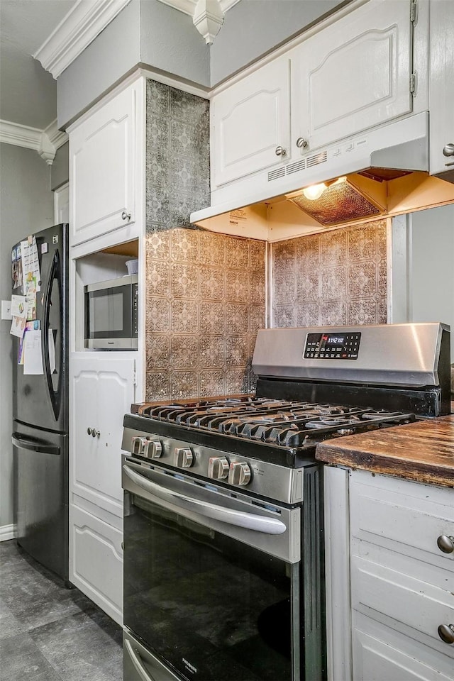 kitchen featuring tasteful backsplash, crown molding, white cabinetry, and appliances with stainless steel finishes