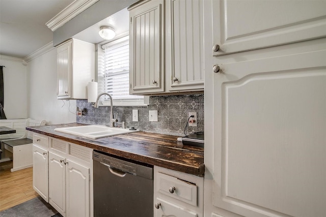 kitchen featuring white cabinets, dishwasher, sink, and wooden counters