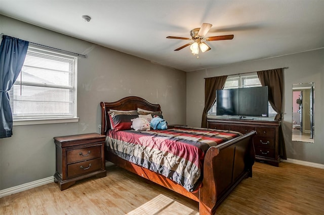 bedroom with multiple windows, ceiling fan, and light wood-type flooring