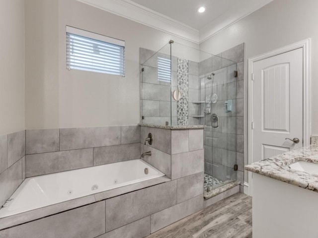 bathroom featuring shower with separate bathtub, vanity, ornamental molding, and hardwood / wood-style floors