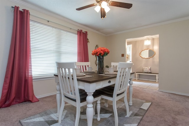 carpeted dining space with ceiling fan and ornamental molding