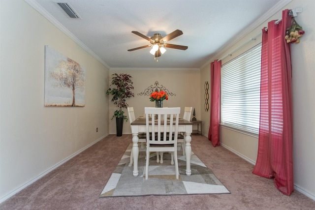 dining space featuring light carpet, ceiling fan, and ornamental molding