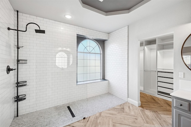 full bath with recessed lighting, vanity, a tray ceiling, and a walk in shower