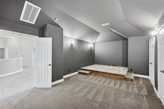 additional living space with lofted ceiling, carpet flooring, visible vents, and baseboards