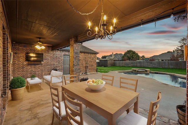 patio terrace at dusk with outdoor dining space, a pool with connected hot tub, a fenced backyard, and ceiling fan