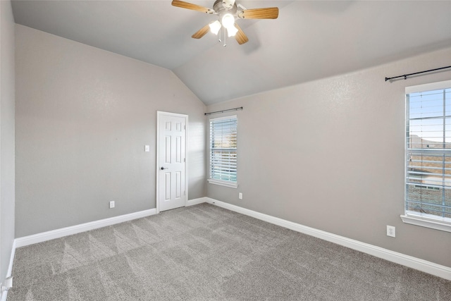 spare room with ceiling fan, light carpet, and vaulted ceiling