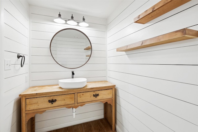 bathroom featuring wood walls and vanity