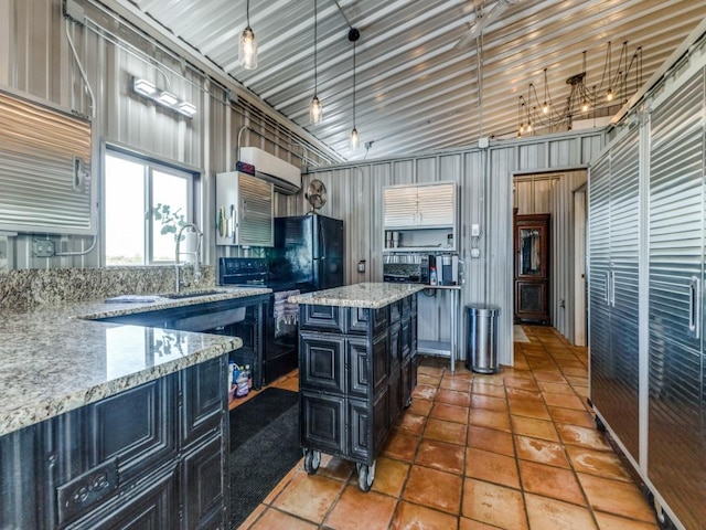 kitchen featuring light stone counters, hanging light fixtures, a kitchen island, tile patterned flooring, and black appliances