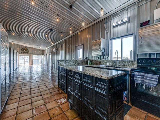 kitchen with a kitchen island, sink, hanging light fixtures, black range with electric stovetop, and tile patterned floors