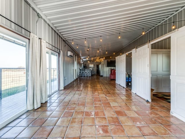 hallway featuring a barn door, tile patterned flooring, and a wall unit AC