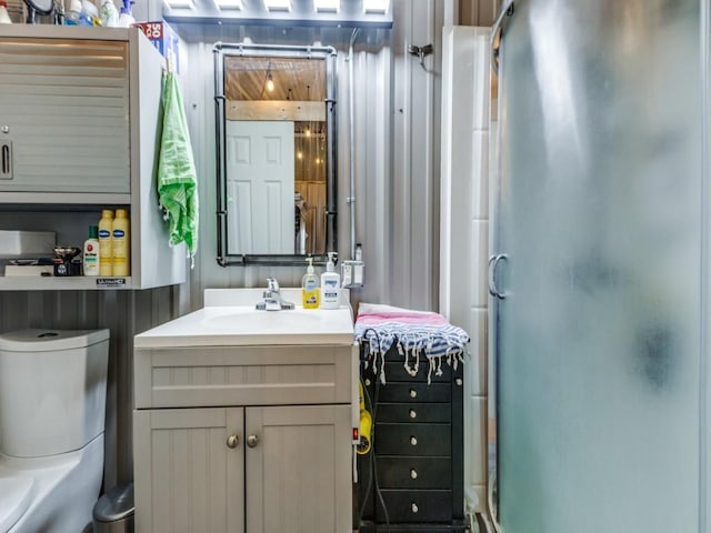 bathroom with vanity, wooden walls, and walk in shower