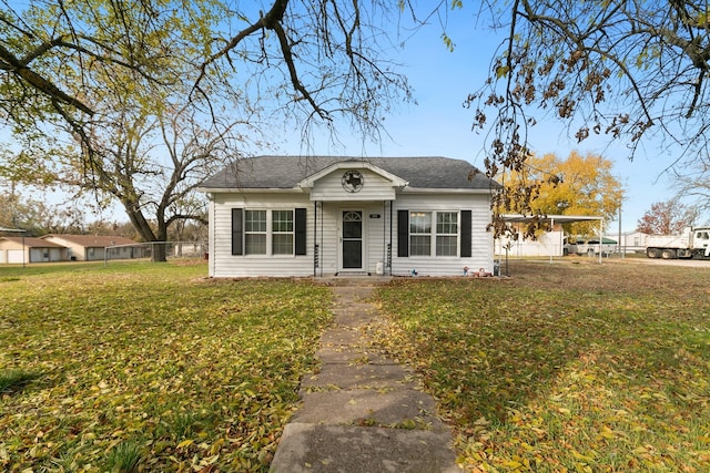 view of front of home with a front yard and a carport