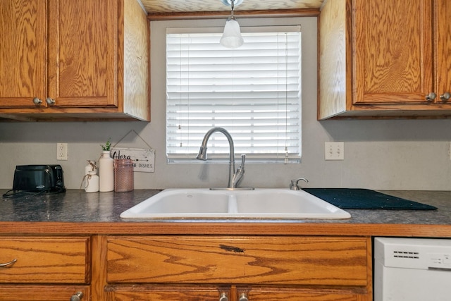 kitchen with white dishwasher, sink, and pendant lighting