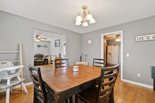 dining area featuring ceiling fan with notable chandelier and light hardwood / wood-style floors