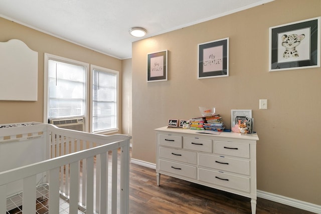 bedroom featuring dark hardwood / wood-style flooring, ornamental molding, and a nursery area