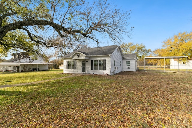 view of front of house with a carport and a front lawn