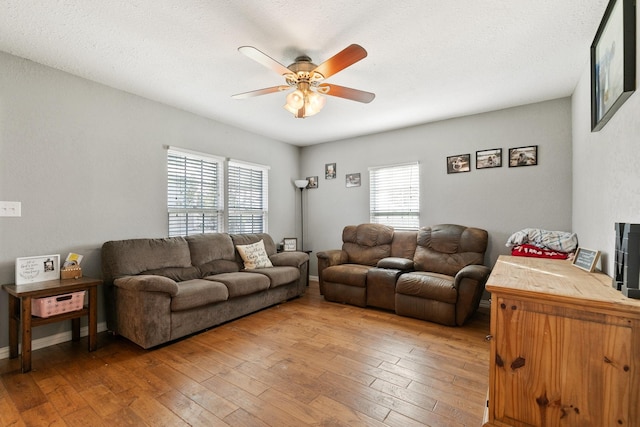 living room featuring hardwood / wood-style flooring, a textured ceiling, and ceiling fan